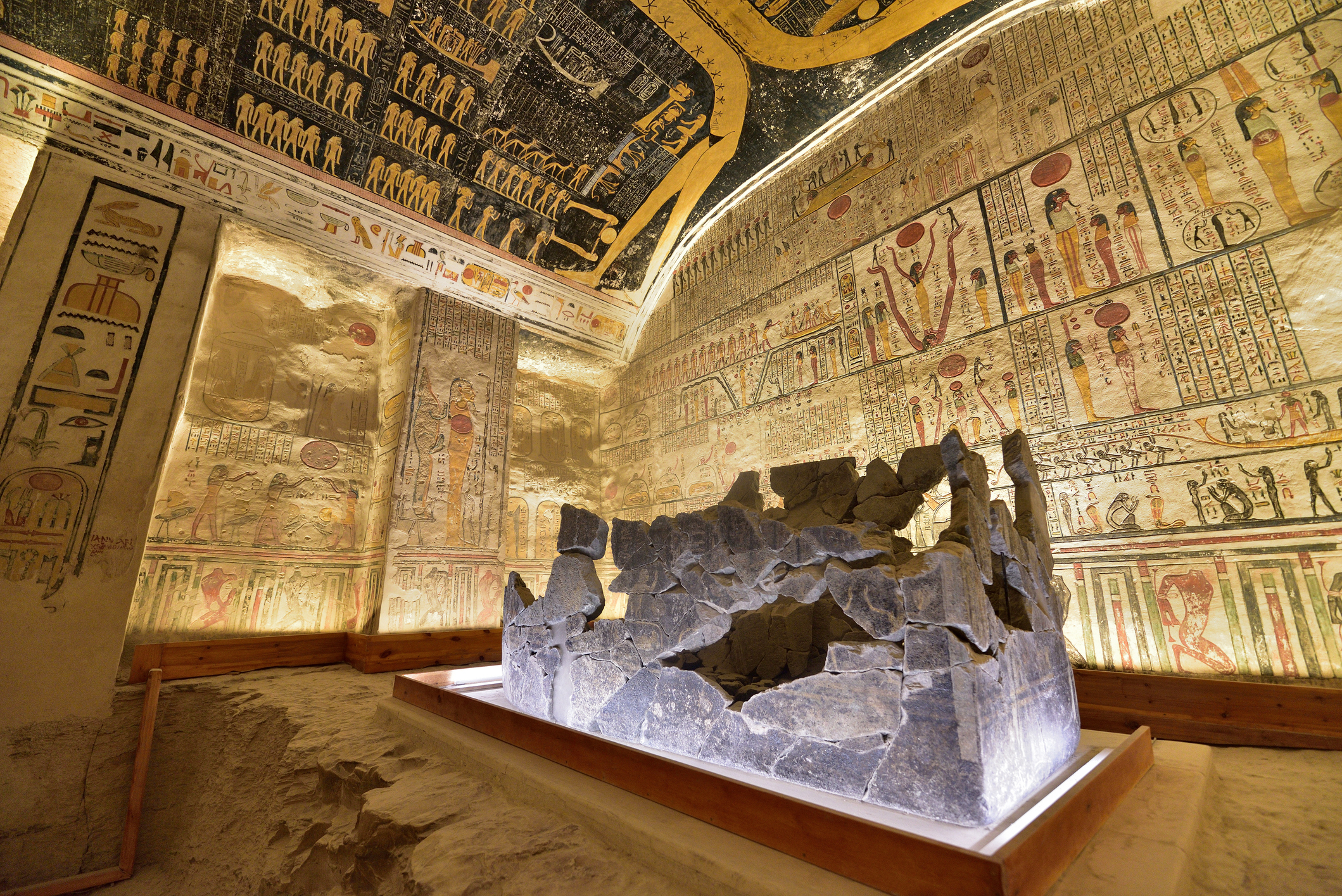 De tombe van Ramses II in de Vallei der Koningen, met uitgehouwen rotswanden, kleurrijke hiërogliefen en een sarcofaag in het midden van de kamer.