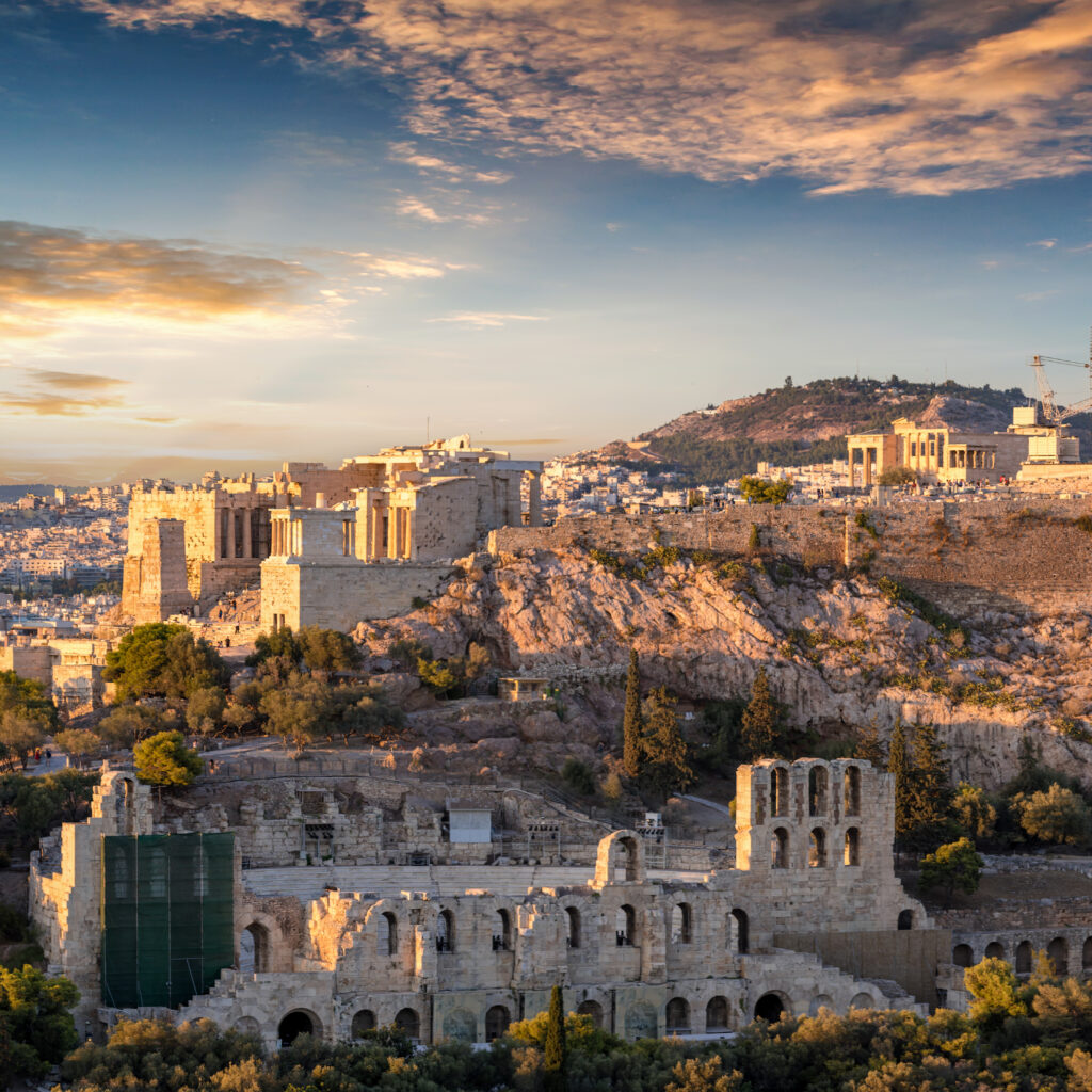 Panoramisch beeld van de Acropolis in Athene bij zonsondergang, één van de plekken die aanvoelen als tijdreizen, met het Parthenon en historische ruïnes bovenop de heuvel.