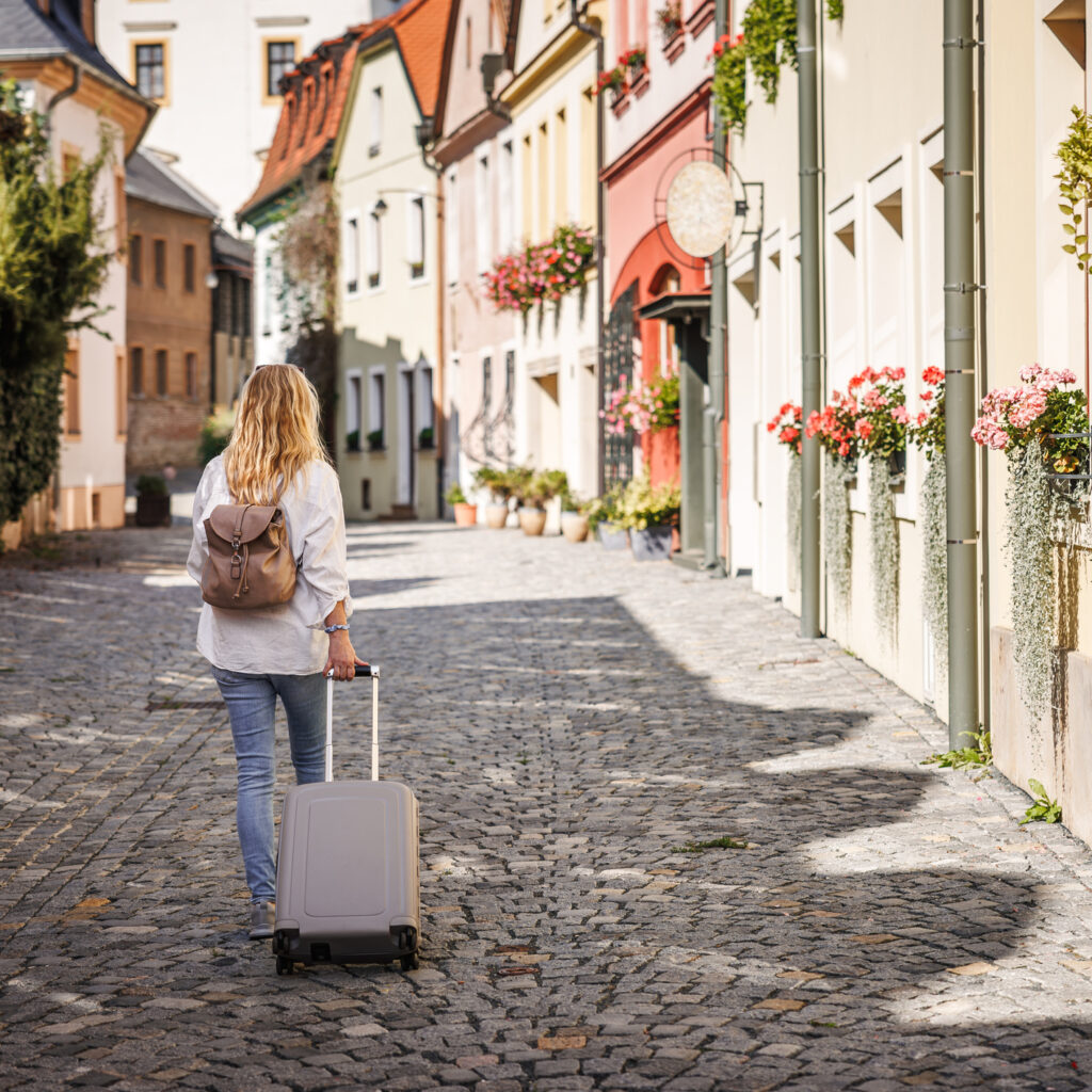 vrouw op reis in stadje met koffer